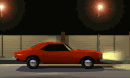 A red muscle car under a streetlight